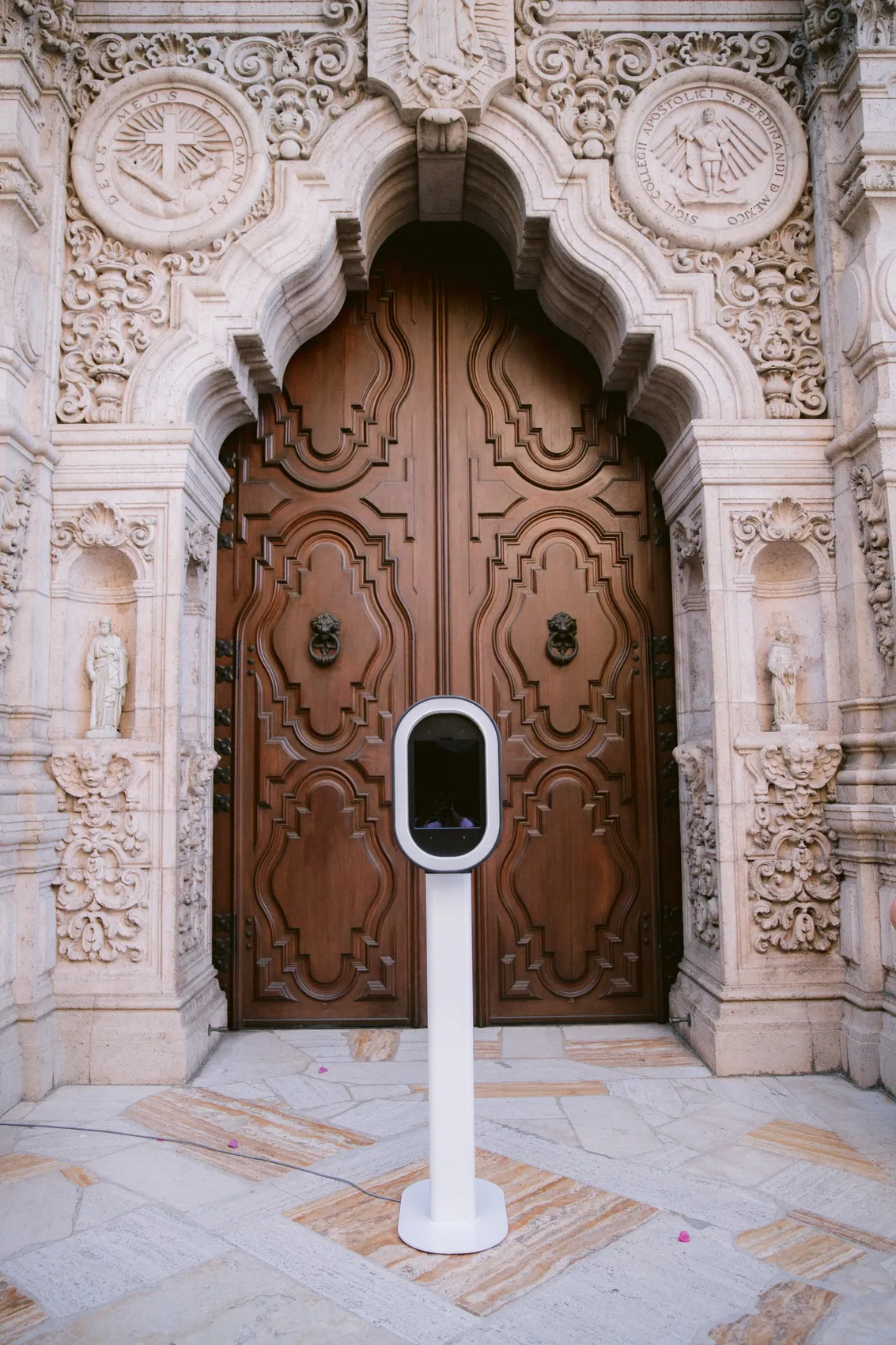 An M3 Fotobooth open air booth set up in front of a carved wooden doorway