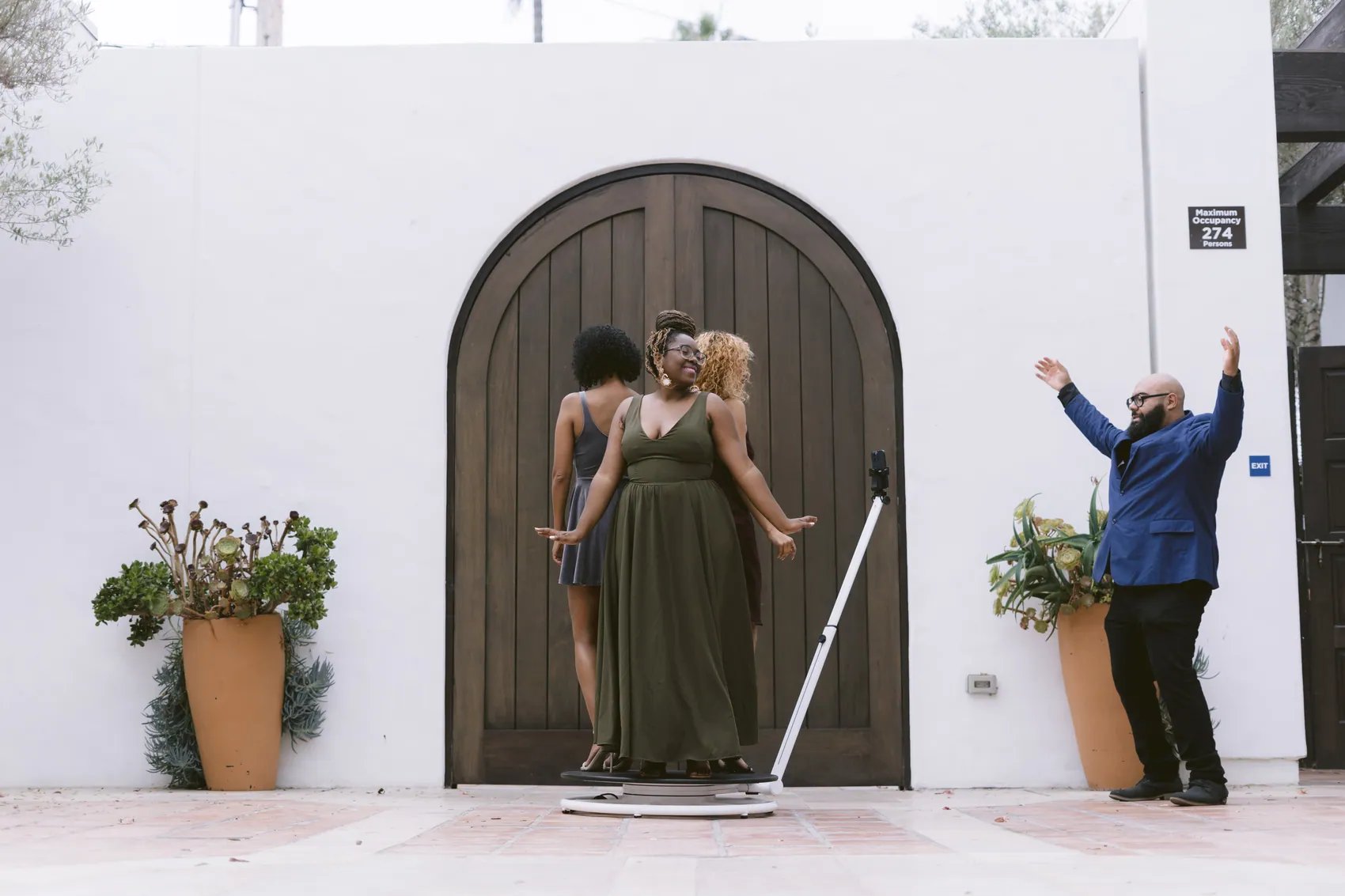 Two guests posing in an archway while an attendant cheers them on