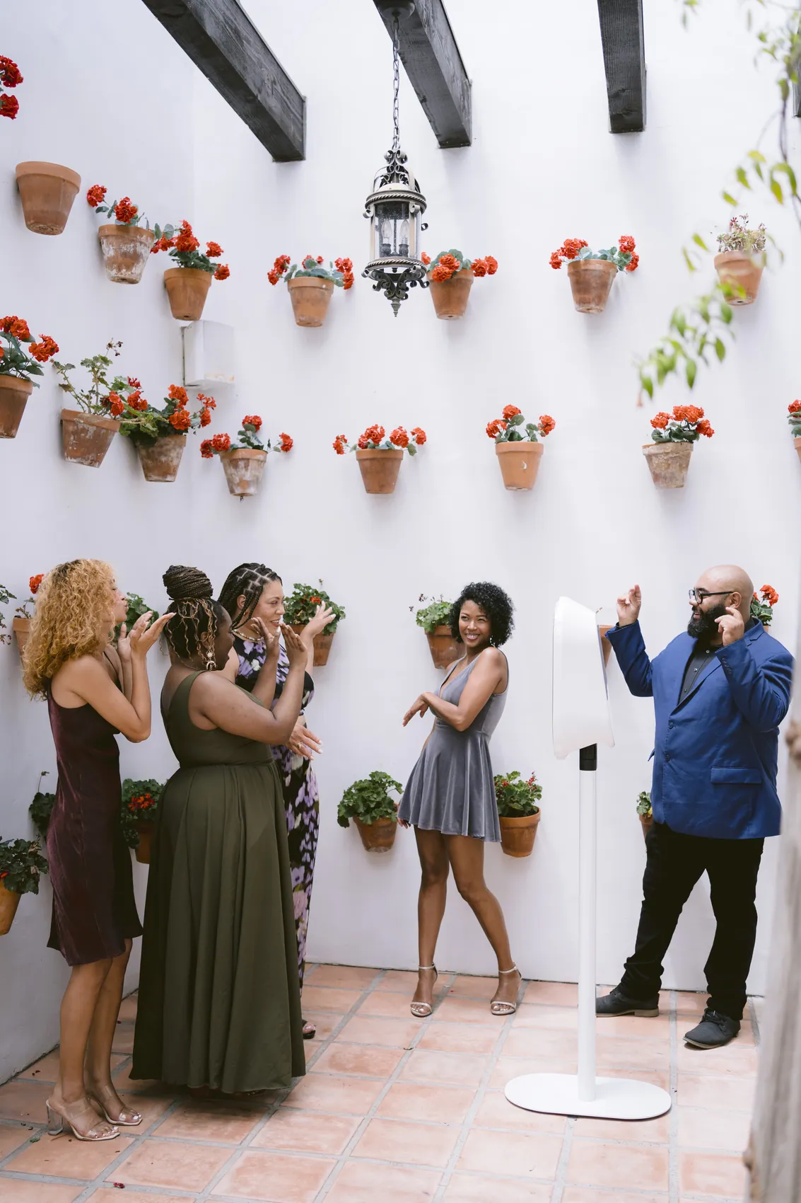 Guests laughing at the booth beside a wall of terracotta flower pots